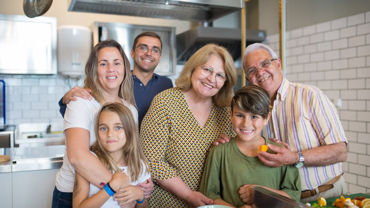 Happy family of six enjoying time together in a modern kitchen setting.